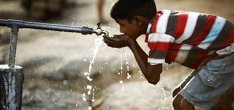 Día del agua: un niño bebe agua de un grifo de la calle