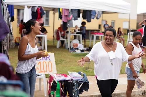 Moradoras conversam animadamente em evento realizado para envolver a comunidade e mediar conflitos