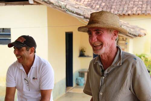 Agricultores sorriem em propriedade de reestruturação produtiva