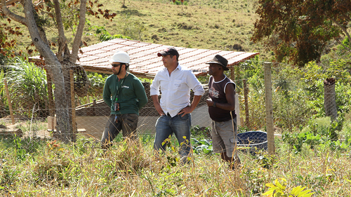 Employees and farmer observe the work done in the field
