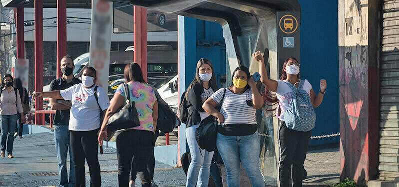 Mulheres em ponto de ônibus: BRT e segurança no transporte