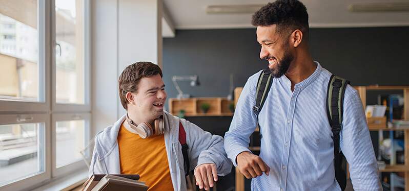 Anticapacitismo Synergia Guide 2022 - Boy with Down syndrome greets black boy. adobe stock photo