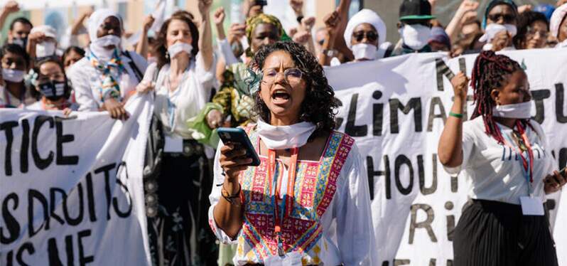 Activistas-vestidas-de-blanco-se-juntan-en-solidaridad-para-resaltar-que-no-hay-justicia-climática-sin-justicia-social_Foto-Marie-Jacquemin_Greenpeace