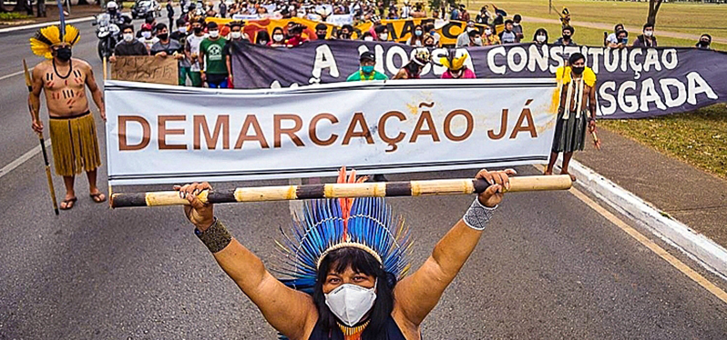 Lucha de los pueblos indígenas: Indígenas piden demarcación con un cartel. Foto: Ninja Media