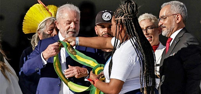 Aline Sousa, recolectora de materiales, entrega la banda presidencial a Luís Inácio Lula da Silva durante la ceremonia de toma de posesión. Foto: Adriano Machado/Reuters