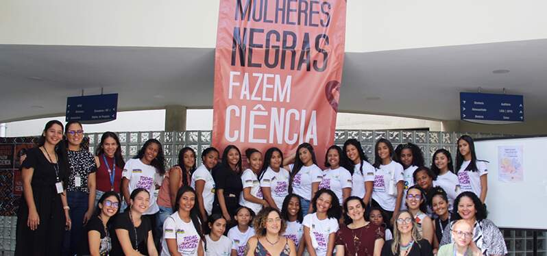 Grupo de mujeres frente a la pancarta las mujeres negras hacen ciencia. Foto: CMN/Ana Roberta Amorim