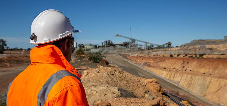 Funcionário em frente a barragen de rejeitos. Foto: Adobe Stock