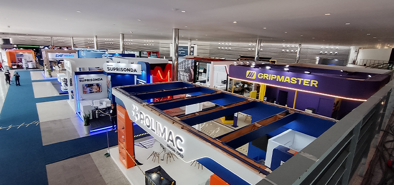 Vista panorâmica da área de exposição da Exposibram 2026, com estandes de empresas fornecedoras de equipamentos, serviços e tecnologias para o setor de mineração, destacando marcas expositoras e a estrutura da feira de negócios.